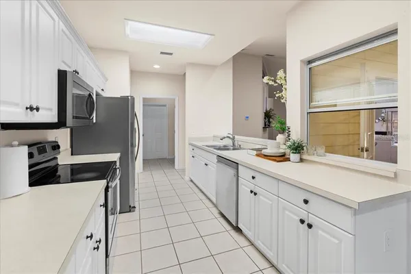 a kitchen with stainless steel appliances a sink cabinets and a window