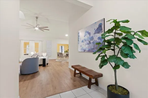 a living room with furniture a chandelier and a potted plant