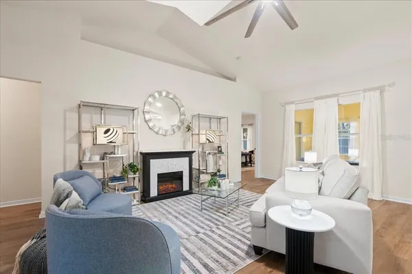 a living room with furniture a fireplace and a chandelier