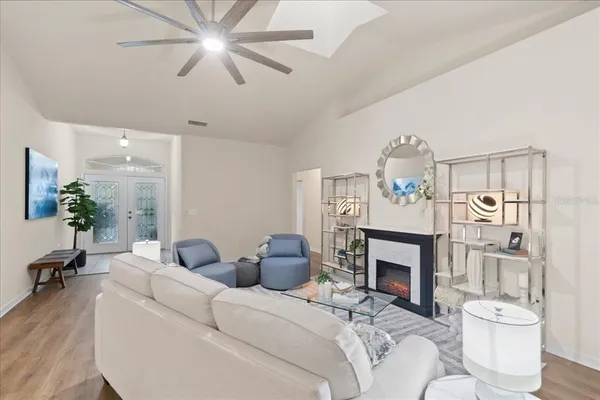 a living room with furniture a fireplace and a chandelier