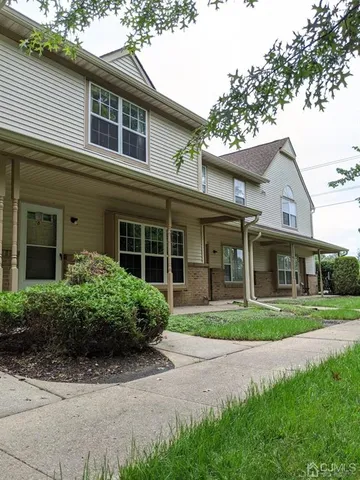 a front view of a house with a yard and potted plants