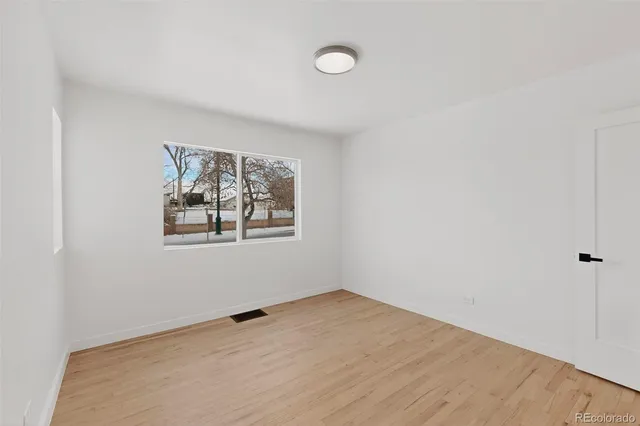 a view of a room with wooden floor and white doors