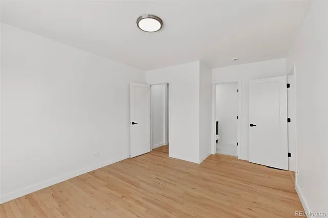 a large white kitchen with kitchen island a sink wooden floor and a chandelier