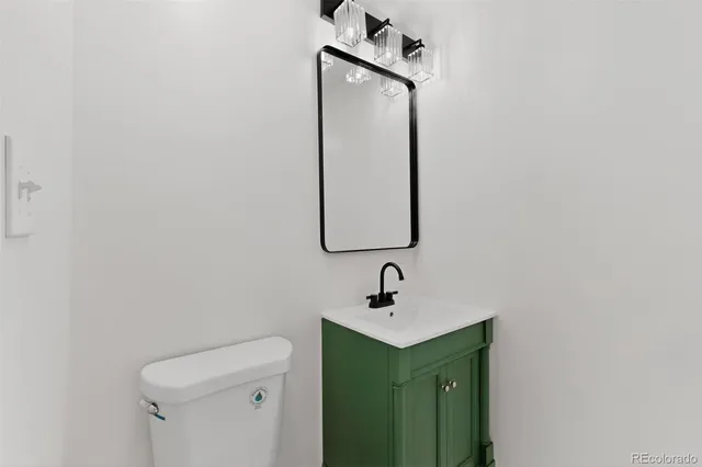 a bathroom with a sink vanity mirror and toilet