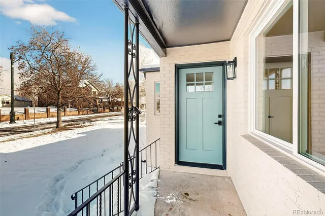 a view of a porch with a table and chairs and floor to ceiling window