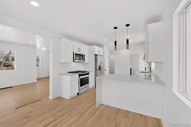 a large white kitchen with stainless steel appliances