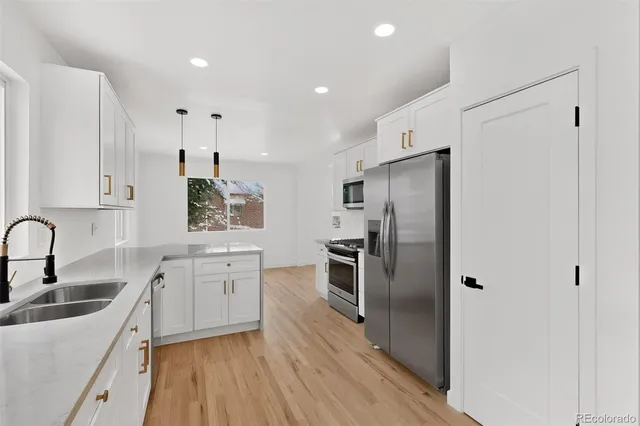 a kitchen with stainless steel appliances a refrigerator sink and stove