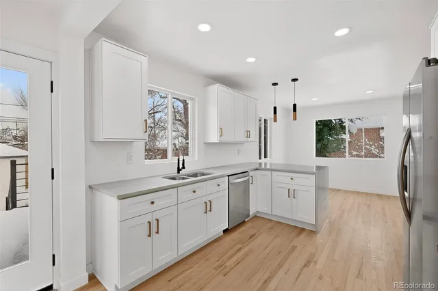 a view of an empty room with wooden floor and window