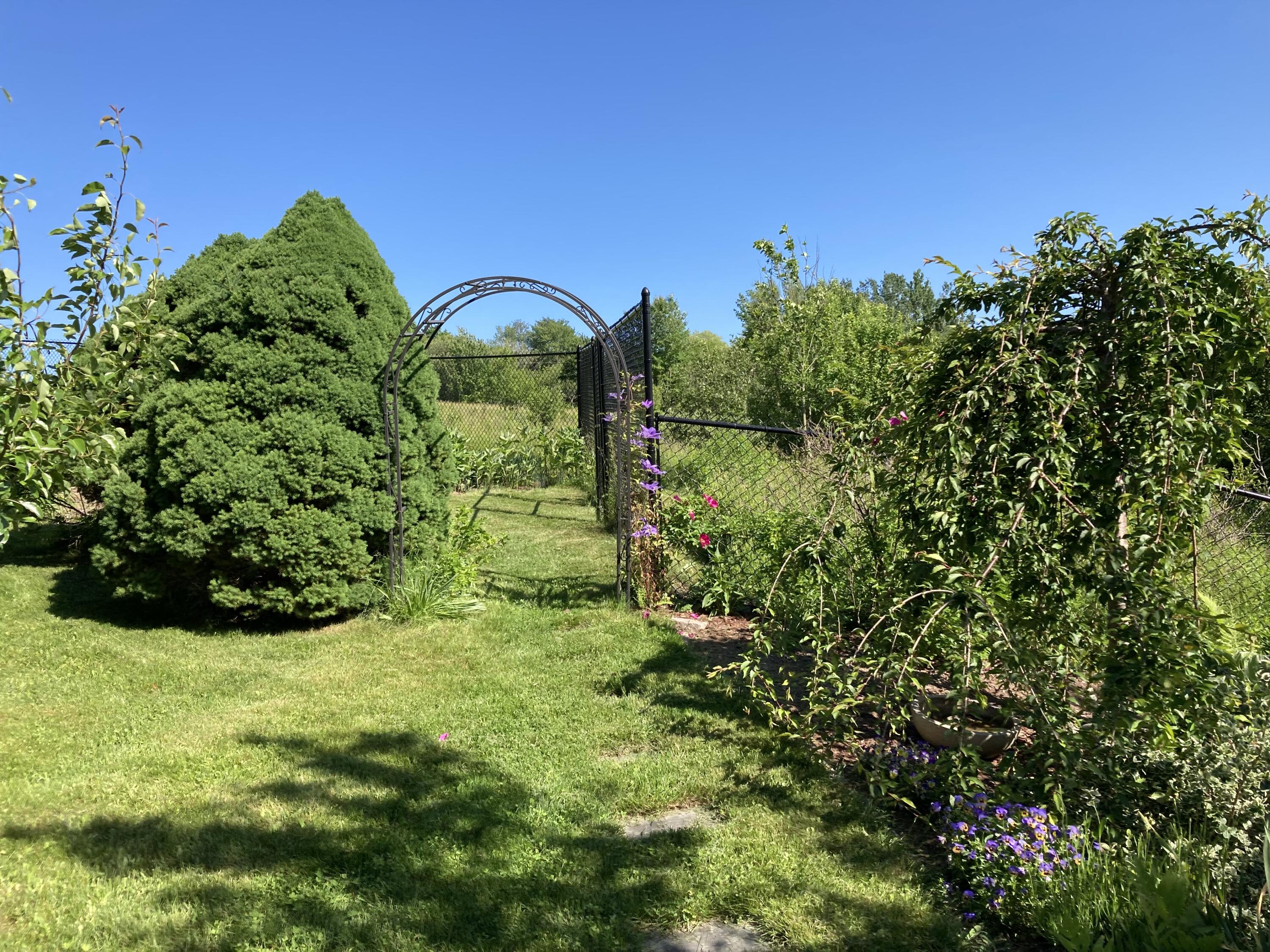 32 Boulder Cv Way Lamoine, ME 04605 - Photo 20 of 37 Through the arch to more garden area.