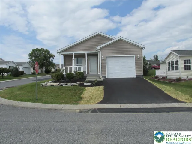 a view of a house with a yard and large tree