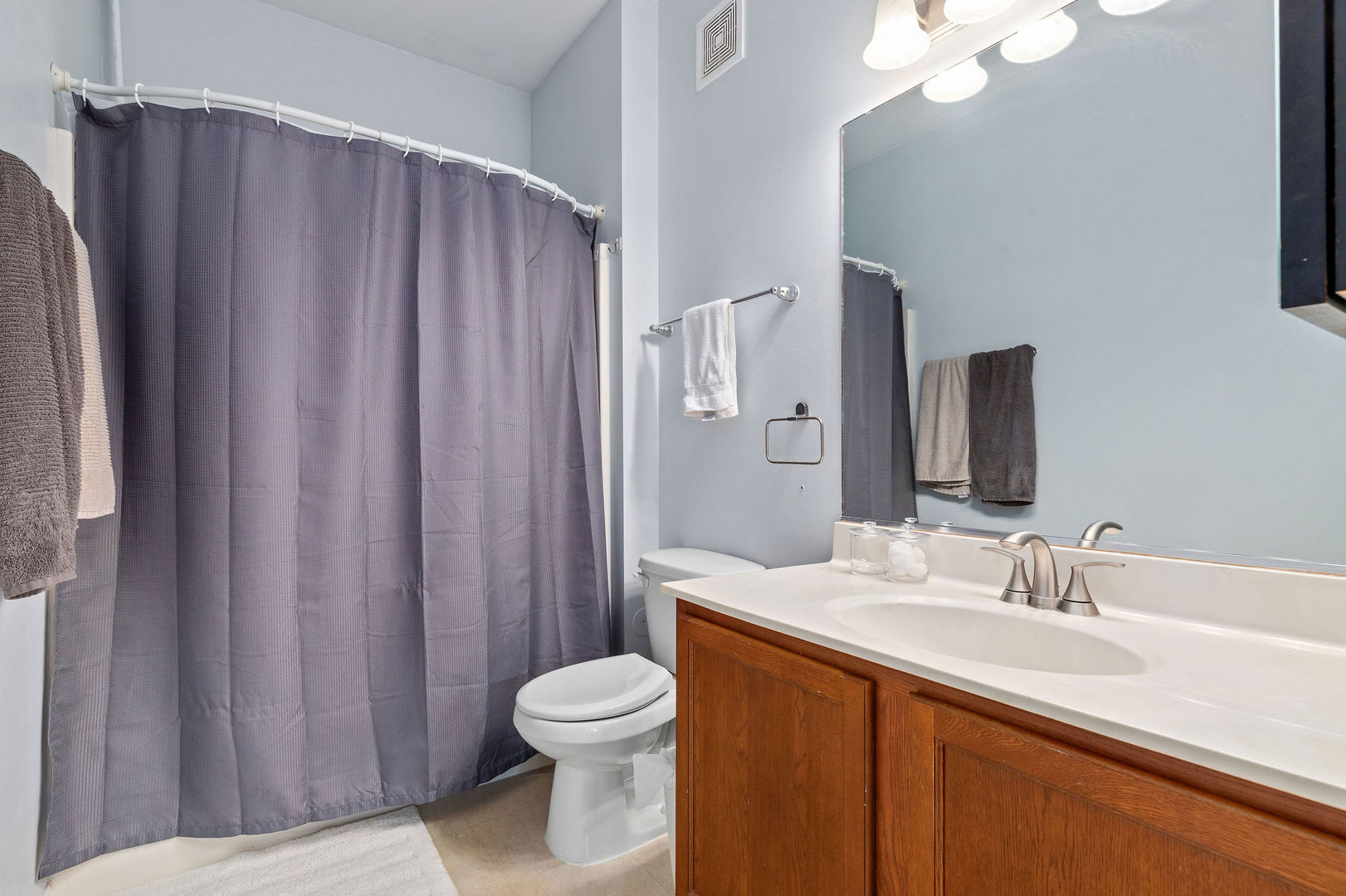 4486 Timber Ridge Court, Unit 4486 Joliet, IL 60431 - Photo 14 of 22 a bathroom with a sink a toilet a mirror and shower curtain