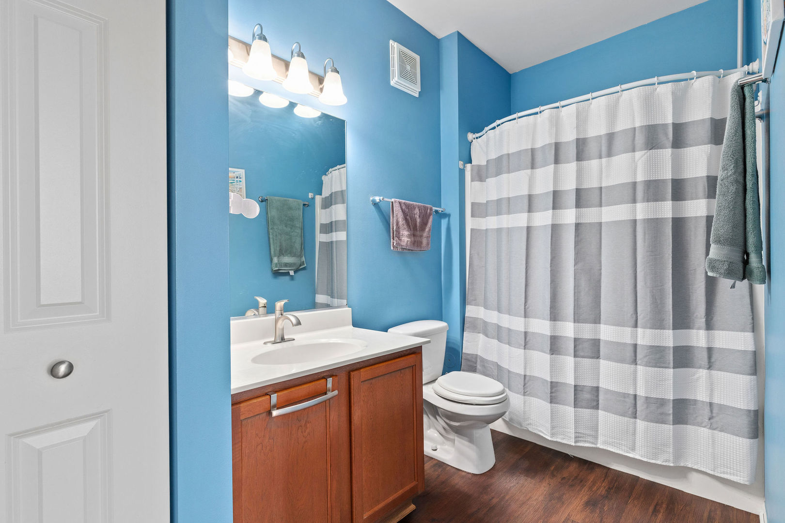 4486 Timber Ridge Court, Unit 4486 Joliet, IL 60431 - Photo 18 of 22 a bathroom with a sink a toilet a mirror and shower curtain
