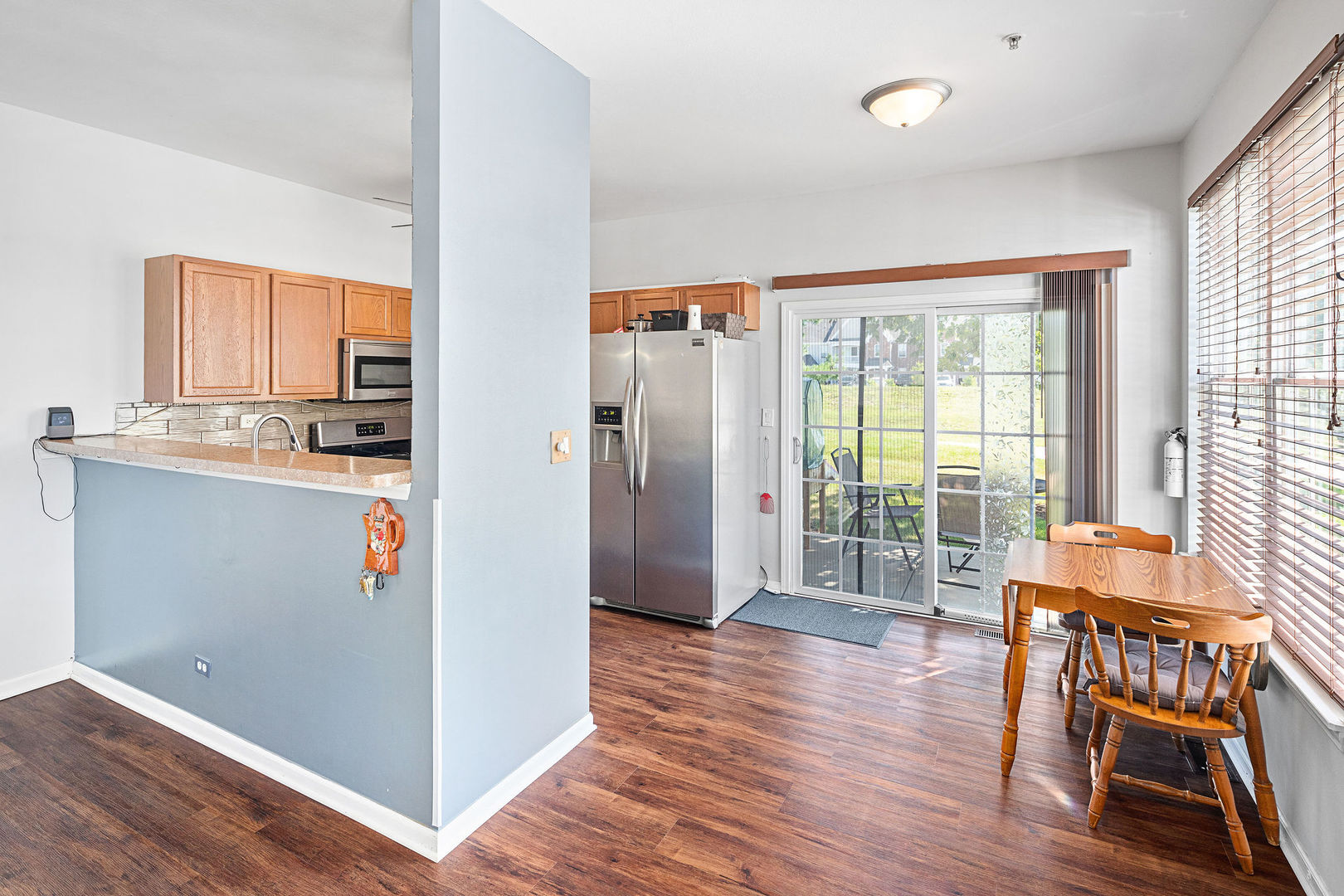 4486 Timber Ridge Court, Unit 4486 Joliet, IL 60431 - Photo 3 of 22 a view of a kitchen with furniture wooden floor and a large window