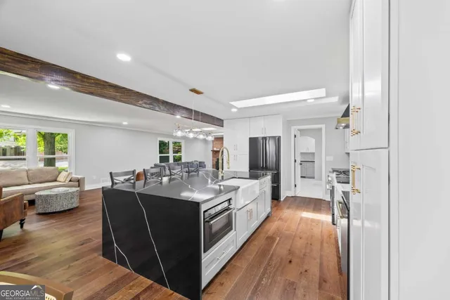 a kitchen with stainless steel appliances a table chairs and a refrigerator