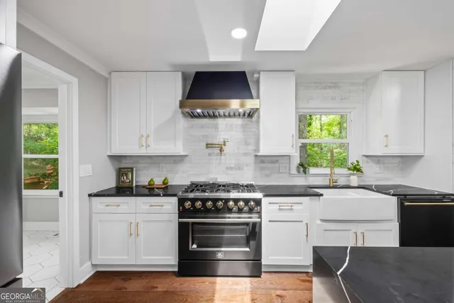 a kitchen with white cabinets and appliances