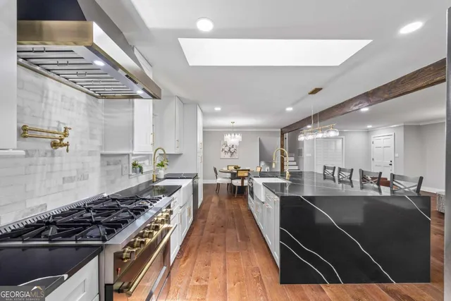 a kitchen with kitchen island granite countertop stainless steel appliances and wooden floor