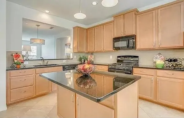 a kitchen with stainless steel appliances granite countertop a sink stove and cabinets