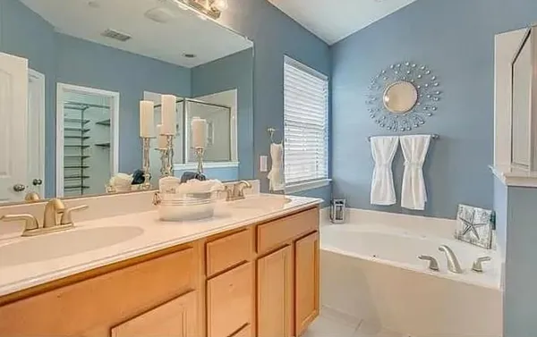 a bathroom with a tub sink and mirror
