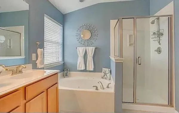 a bathroom with a tub sink and mirror