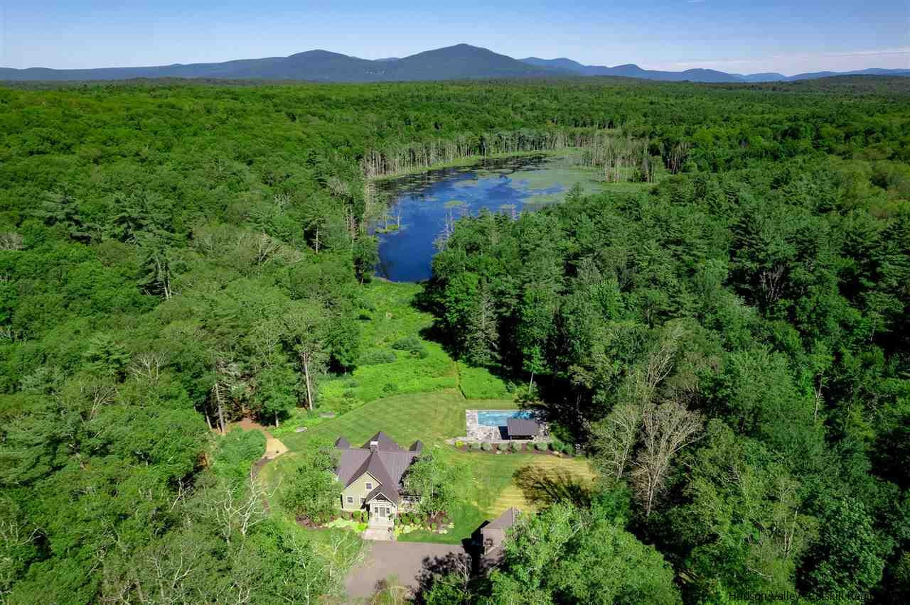 a view of a lush green forest with a house