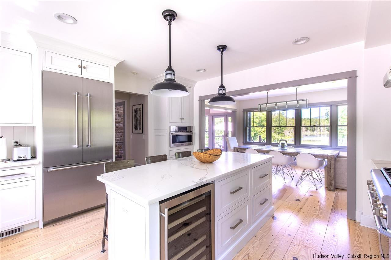 311 Buck Road Stone Ridge, NY 12484 - Photo 13 of 35 a view of a kitchen with a stove a faucet cabinets and a wooden floor