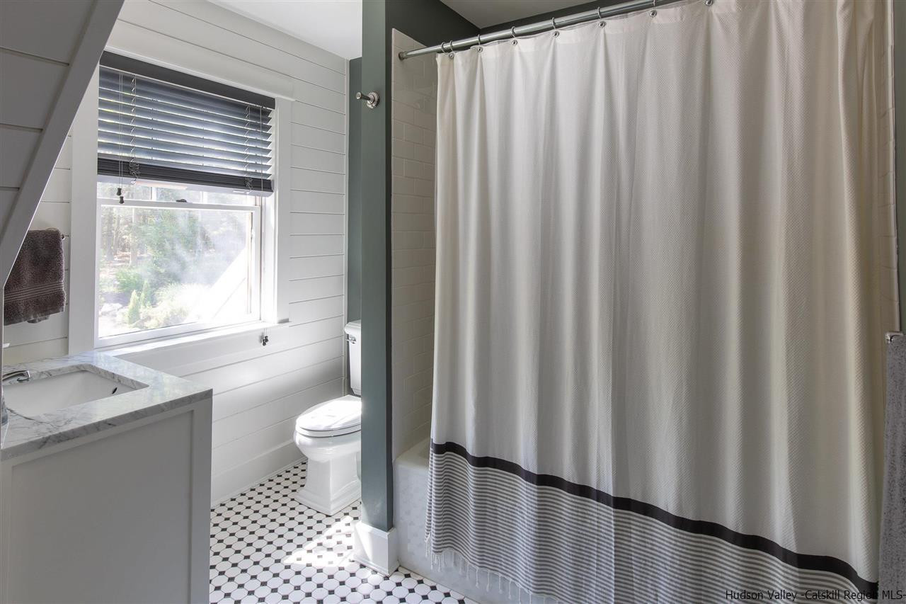 311 Buck Road Stone Ridge, NY 12484 - Photo 26 of 35 a bathroom with a granite countertop sink toilet and a mirror