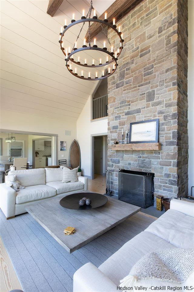 311 Buck Road Stone Ridge, NY 12484 - Photo 10 of 35 a living room with furniture a fireplace and a table