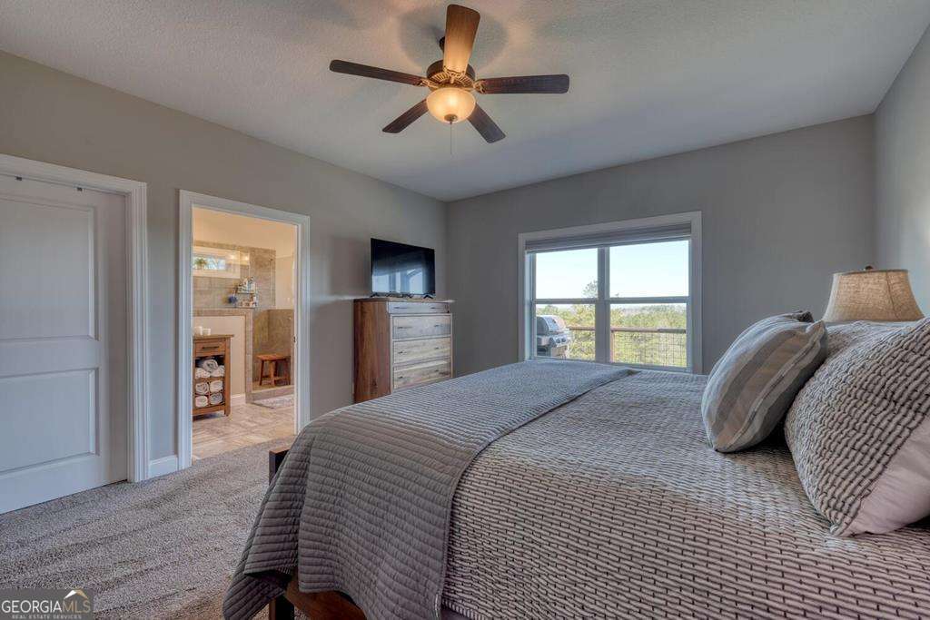 1309 Ridge Pointe Way, Unit 284 Blairsville, GA 30512 - Photo 23 of 75 a bedroom with a large bed a chandelier and dresser