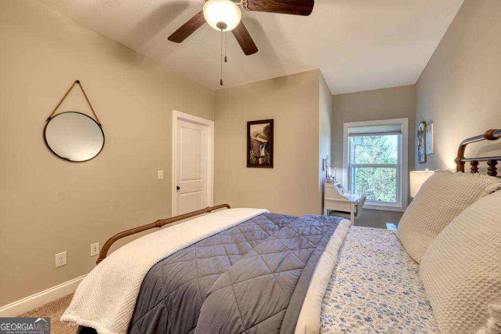 1309 Ridge Pointe Way, Unit 284 Blairsville, GA 30512 - Photo 29 of 75 a bedroom with a large bed and chandelier fan