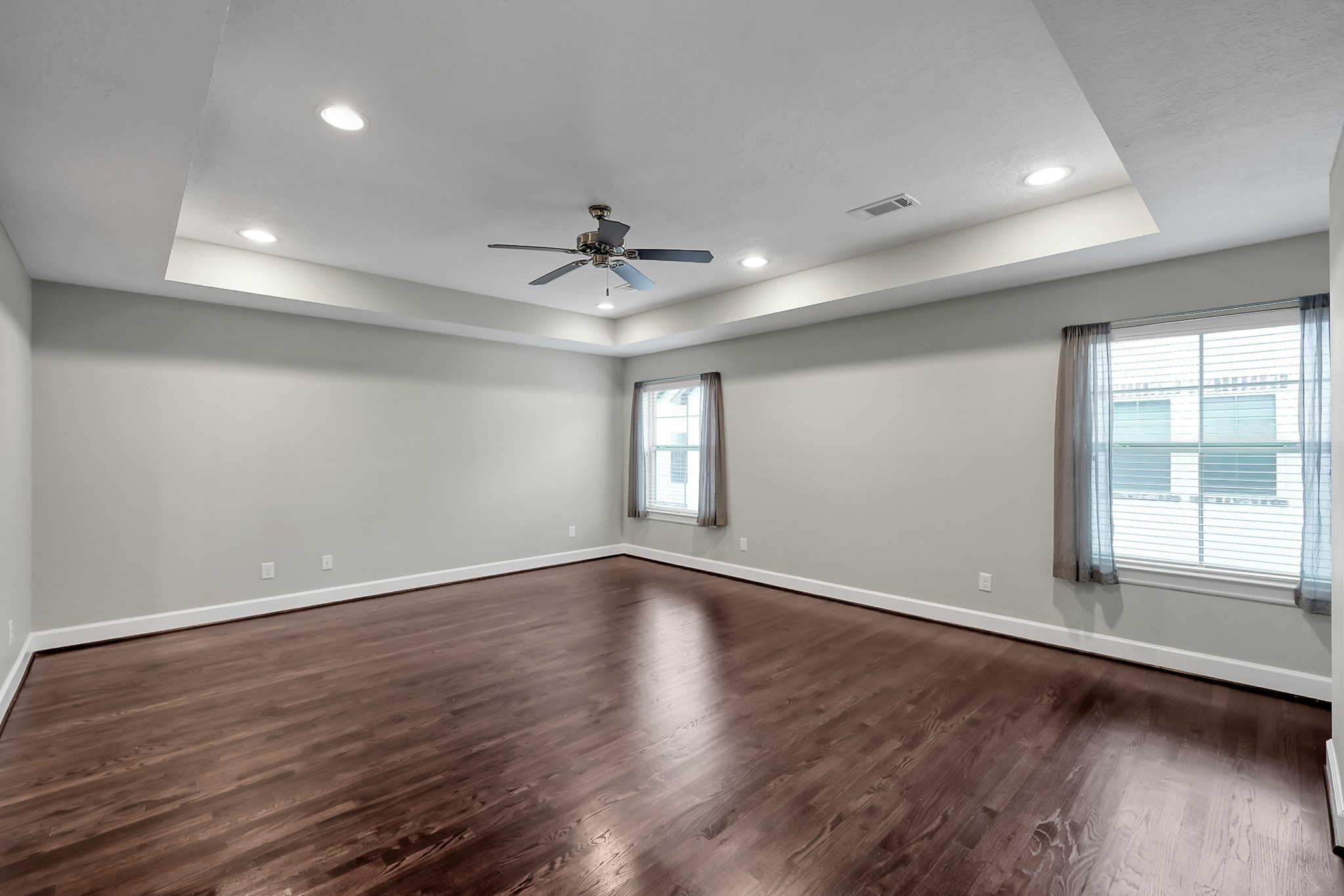 351 West 26th Street Houston, TX 77008 - Photo 25 of 45 This spacious room features sleek hardwood floors, neutral walls, and recessed lighting. It includes a ceiling fan for comfort and two large windows that provide natural light, making it ideal for a versatile living area or bedroom.