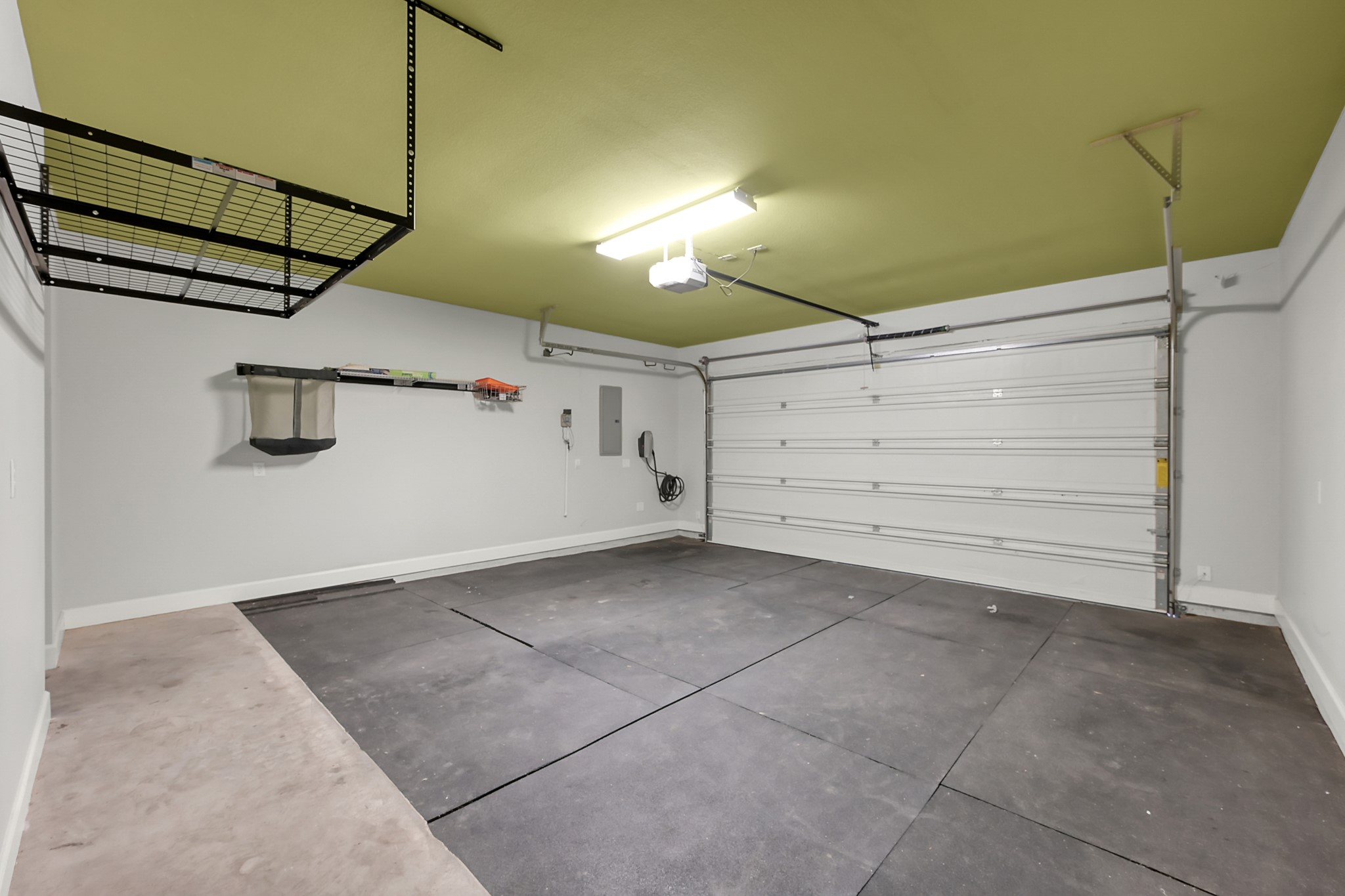 351 West 26th Street Houston, TX 77008 - Photo 41 of 45 This spacious garage features a modern overhead storage rack, wall-mounted shelving, and a durable floor. It has a large garage door and ample lighting, ideal for parking and storage.