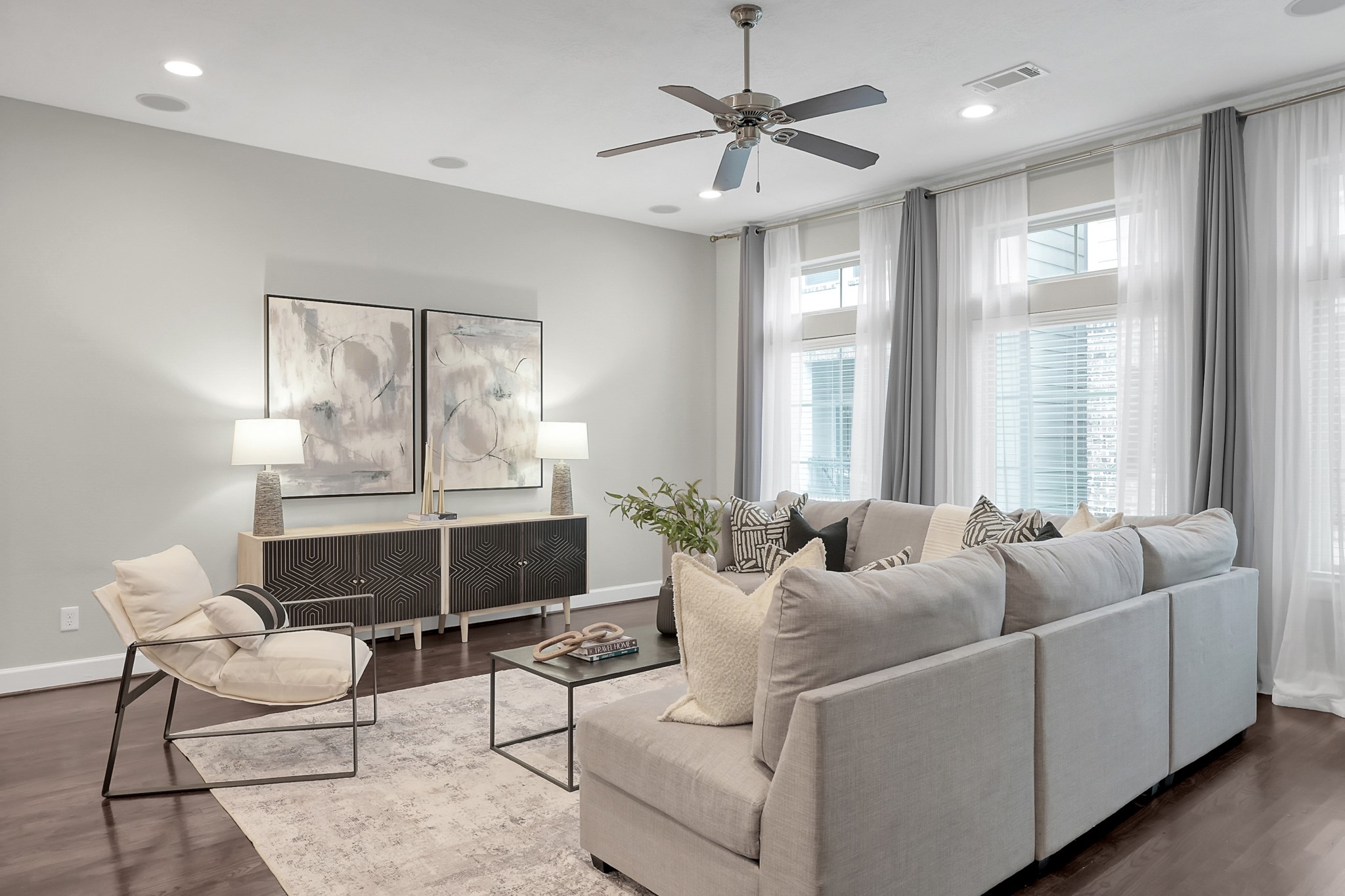 351 West 26th Street Houston, TX 77008 - Photo 5 of 45 Modern living room with abundant natural light, a ceiling fan, and hardwood floors, creating an inviting space.