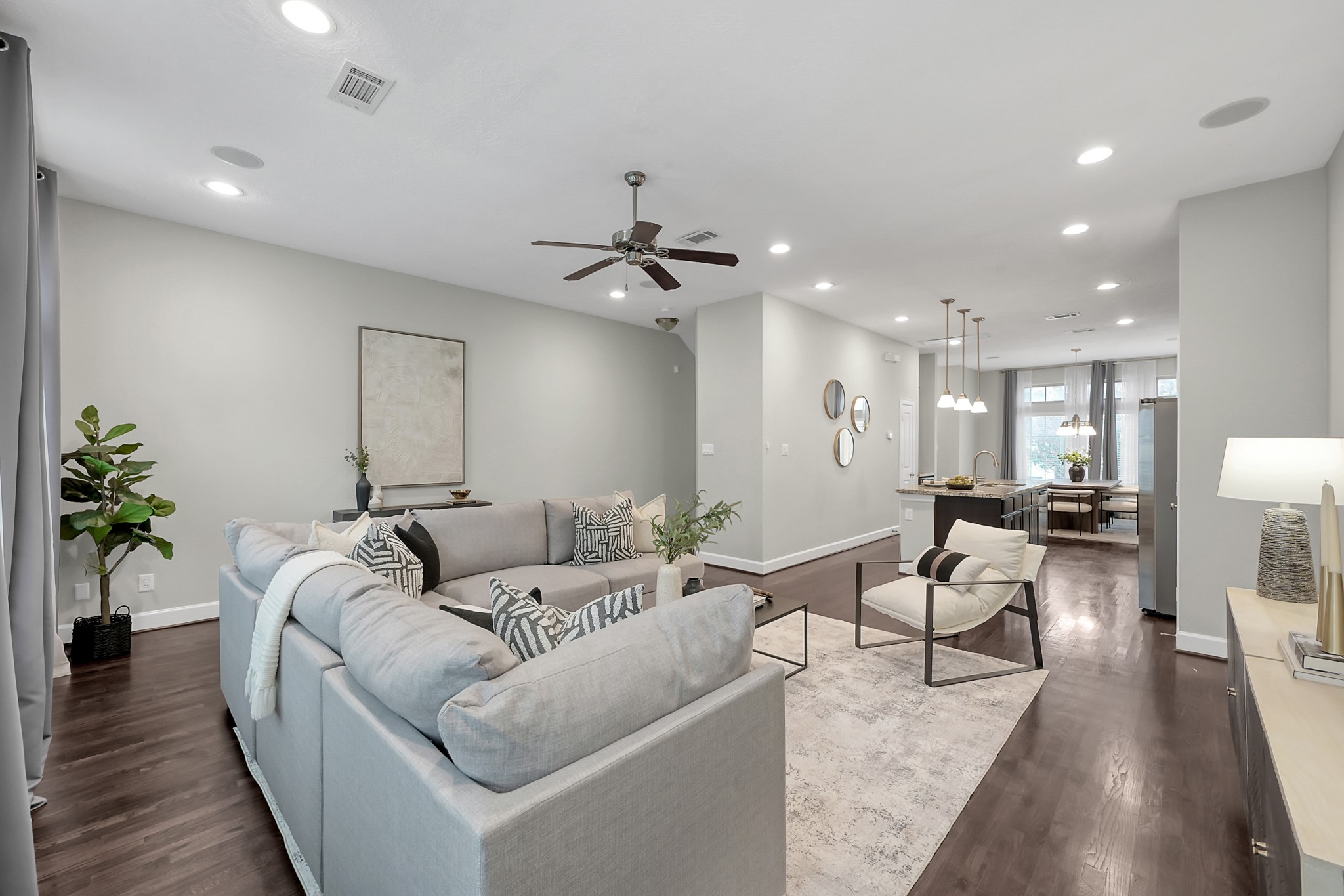 351 West 26th Street Houston, TX 77008 - Photo 45 of 45 This photo showcases a spacious, modern living area with an open floor plan, recessed lighting, and a ceiling fan, seamlessly connecting to a contemporary kitchen and dining area.
