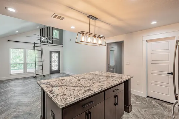 a kitchen with a stove a sink dishwasher a refrigerator and cabinets with wooden floor