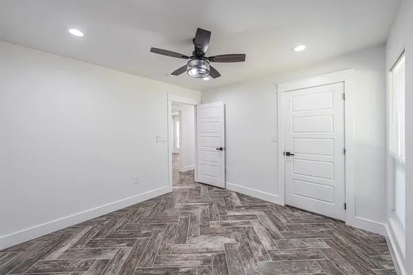 an empty room with a window and ceiling fan