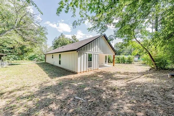 a view of backyard of house with green space