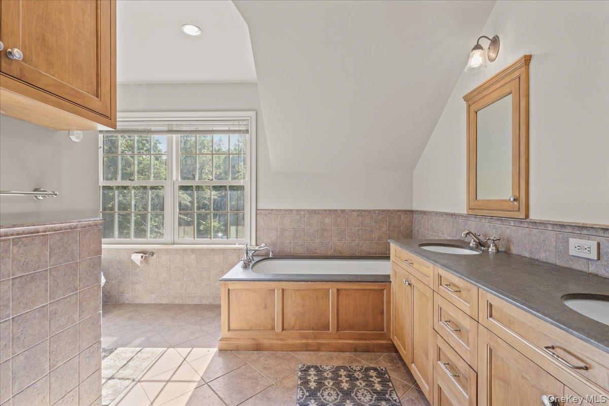 135 Pines Bridge Road Katonah, NY 10536 - Photo 21 of 40 a spacious bathroom with a tub sink and mirror