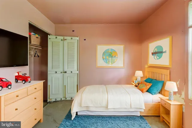 a bedroom with a bed dresser and a window