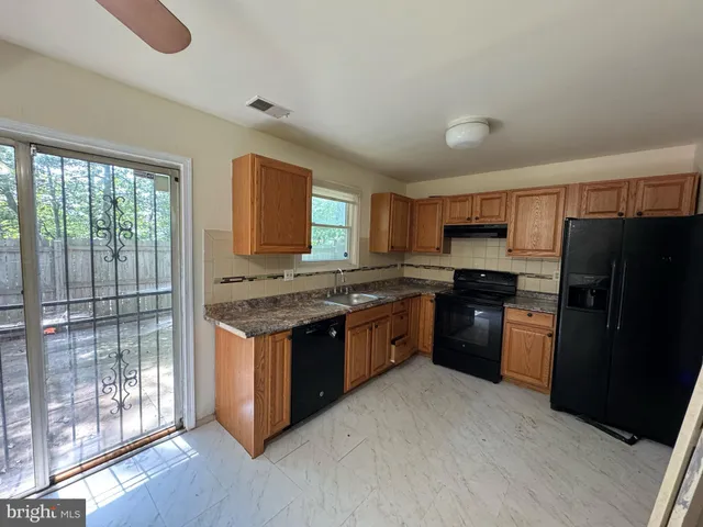 a kitchen with granite countertop stainless steel appliances and wooden cabinets