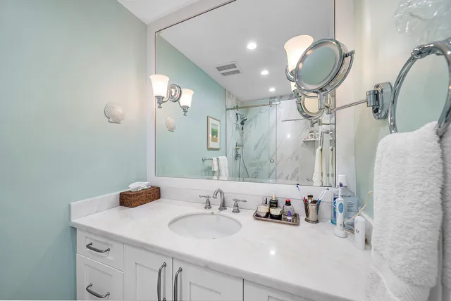 a bathroom with a sink a light fixture and a mirror