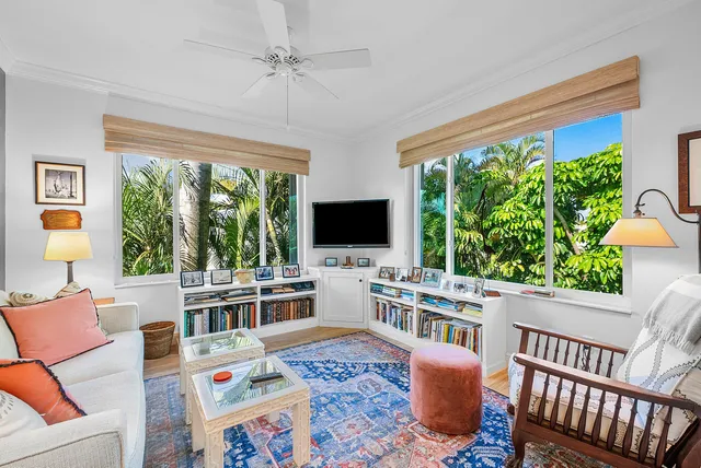 a living room with furniture a flat screen tv and a floor to ceiling window