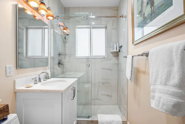 a bathroom with a double vanity sink mirror and shower