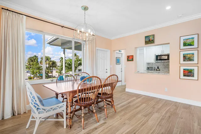 a dining room with furniture a chandelier and wooden floor
