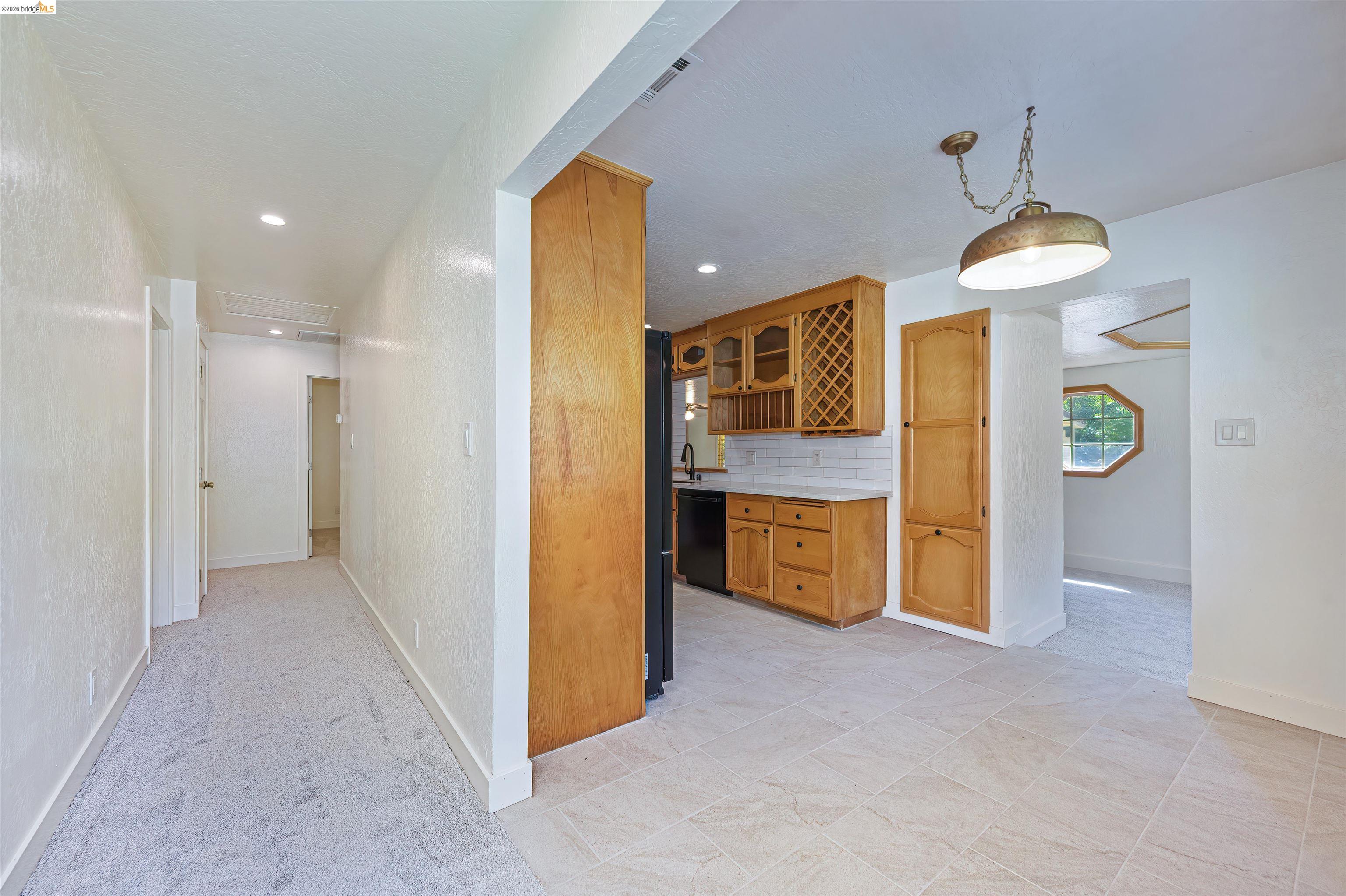 10474 Sheldon Road Elk Grove, CA 95624 - Photo 25 of 83 Kitchen featuring warm wood cabinetry, white subway tile backsplash, and dark appliances