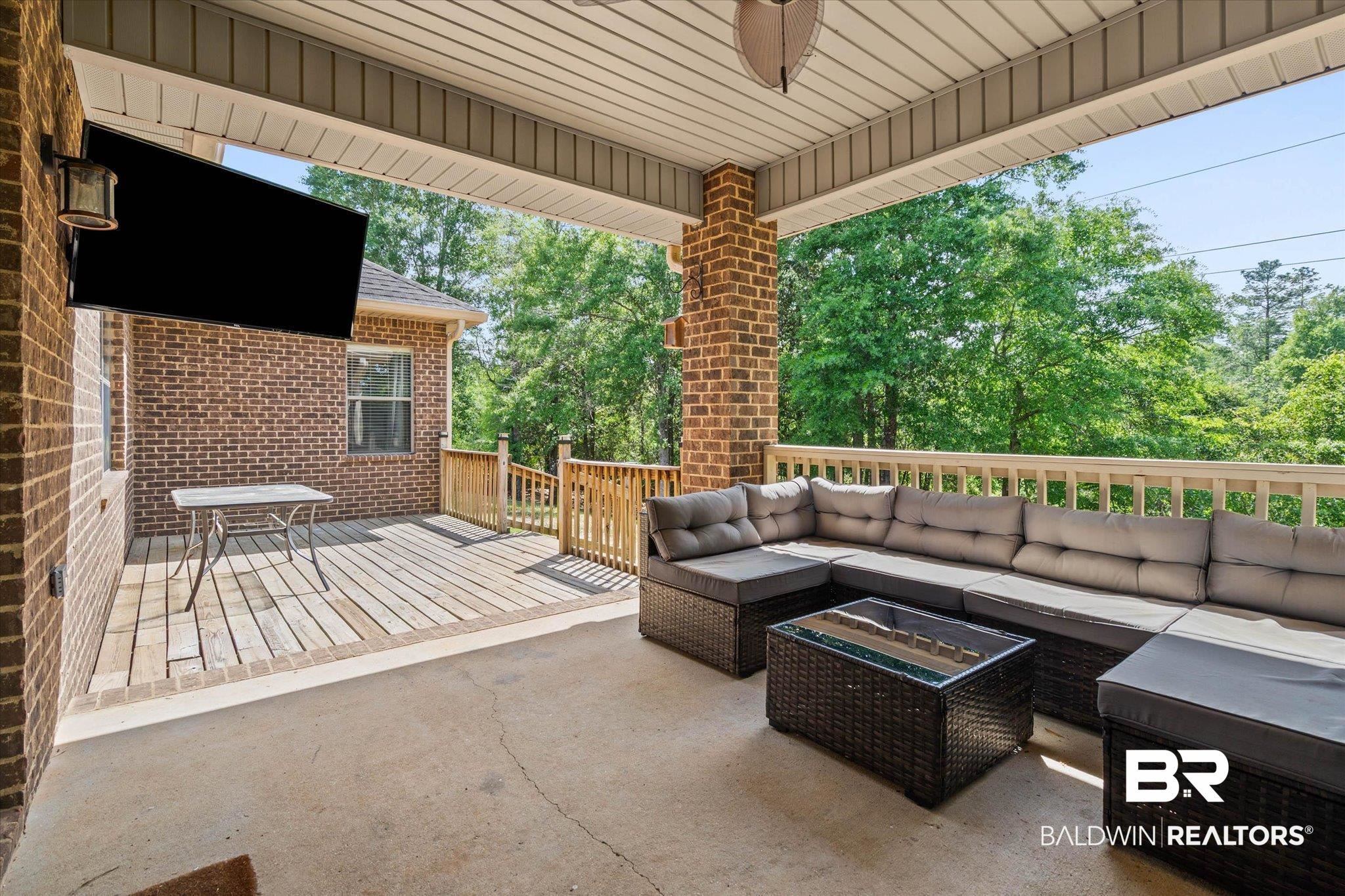 3739 Whitestone Drive Semmes, AL 36575 - Photo 20 of 25 Covered outdoor living area featuring a concrete patio, brick columns, and a wood deck