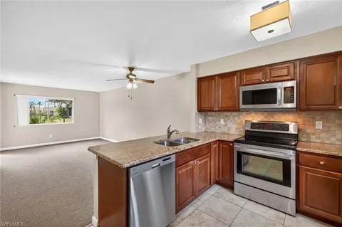 a kitchen with stainless steel appliances granite countertop a stove microwave and sink