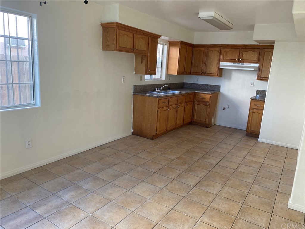 8420 South Broadway Los Angeles, CA 90003 - Photo 13 of 19 a kitchen with stainless steel appliances a sink a stove top oven a counter space and cabinets