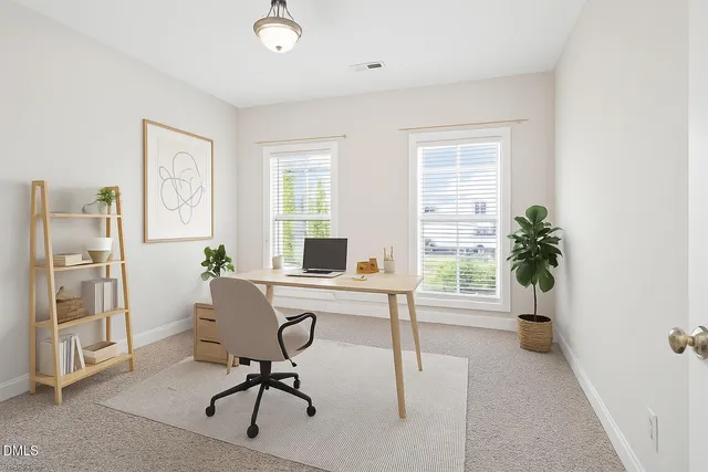 a view of a workspace with furniture and a window