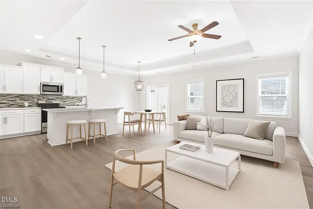 a living room with furniture kitchen and a chandelier