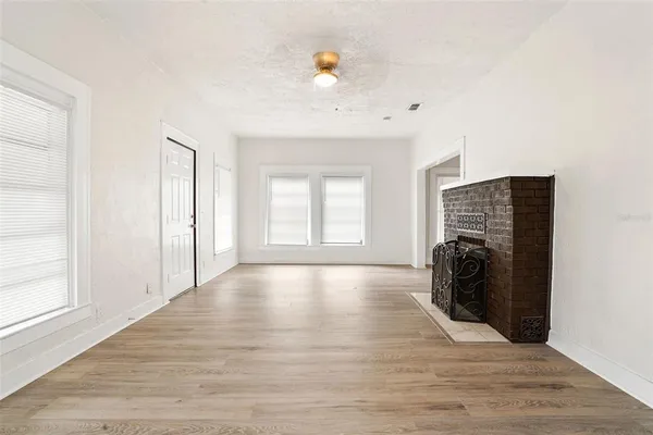 a view of a kitchen with white cabinets and wooden floor